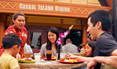 Guests enjoying a meal on the outdoor patio near the sign, 