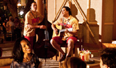 A guitarist and bassist sing songs in the twilight.