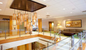 An elegant yellow glass chandelier hangs over the lobby's open stairwell.