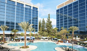 A fraction of one Disneyland Hotel Tower is reflected in the other. The E-Ticket Pool mirrors the sky.