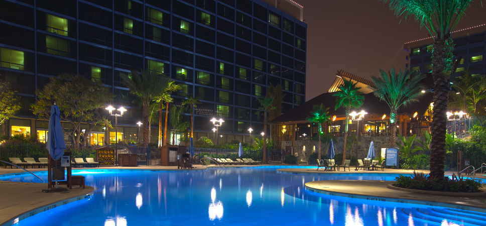 Toma nocturna de la piscina E-Ticket y 2 de las torres del Disneyland Hotel