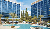 A fraction of one Disneyland Hotel Tower is reflected in the other. The E-Ticket Pool mirrors the sky.