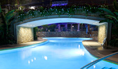 An evening shot of the D-Ticket Pool and footbridge.