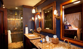 Elegantly designed master bathroom in blues, golds and warm woods.