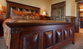 King bed with elaborate wood frame.