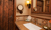 A marble sink, mirrors and wood door.