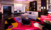 A wide shot of the living area, looking toward the Penthouse's entrance.