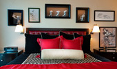 The king bed is surrounded by framed sketches and shelves with statues of Mickey.