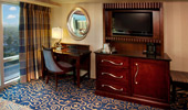 The room's furniture is designed in dark woods, and the carpeting is decorated with blue and gold curlicues.