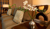 Beautiful room details: delicate flowers in a vase next to a lamp casting warm light