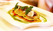 Beautifully plated stuffed ravioli pillows beneath buttered sage leaves.