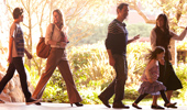 A family of 4 follows a tour guide through the grounds of Disney's Grand Californian Hotel & Spa.