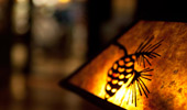 Close up on a lit lamp shade with an an acorn detail