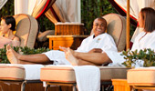 A couple basks and relaxes at a private poolside cabana.