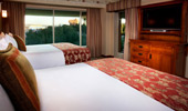 From the queen-size bed see the TV, dresser and exit to balcony.
