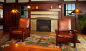 Luxurious leather armchairs flank the fireplace. 