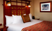 Shot of a king-size bed with wooden headboard