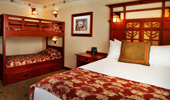Wide shot of room with queen-size bed and bunk beds