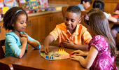 3 young Guests play a board game.