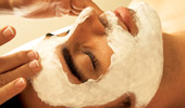 Close up on a man's face while he receives a facial