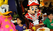 Daisy Duck, Minnie Mouse and 2 young Guests enjoy a happy moment.