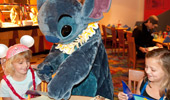 Stitch scribbles his signature for 2 girls.