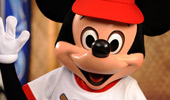 Mickey raises his white-gloved hand to give a high five.