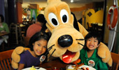 2 young Guests get a hug from Pluto.