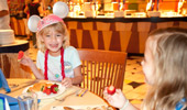 2 girls delight in eating fresh fruit and breakfast foods.