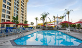 A calm pool surrounded by lounge chairs, with water slides in the background