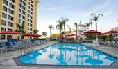 A calm pool surrounded by lounge chairs, with water slides in the background