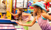 2 girls play a game of skee ball.