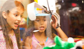 2 girls test their skills with the arcade claw.