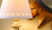 Details on a desk lamp: on the shade, Mickey's silhouette and on the base, a miniature lighthouse motif.