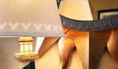 Details on a desk lamp: on the shade, Mickey's silhouette and on the base, a miniature lighthouse motif.