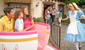  Alice in Wonderland appears to the delight of a family on the Mad T Party attraction